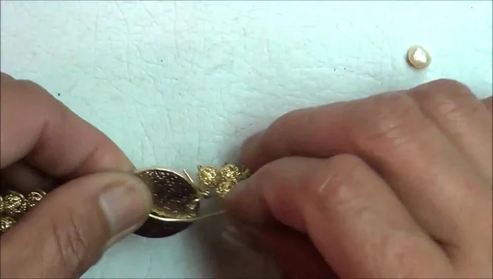 Add freshwater pearl accent: Create a small curl or spiral at the center of the bracelet. Insert the freshwater pearl between the two wire sections. Secure the pearl in place with flat-nose pliers.