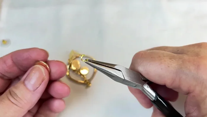 Attach the final large disc to the end of the chain using a jump ring.
