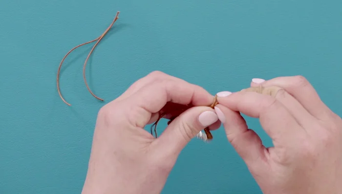 Finishing touches: Tie the remaining tails together with an overhand knot and trim the ends close to the knot. Adjust the length of the clasp tails to your preference.