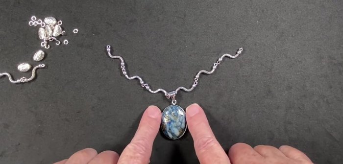 Attach the pendant focal point to the existing pendant bale using jump rings.