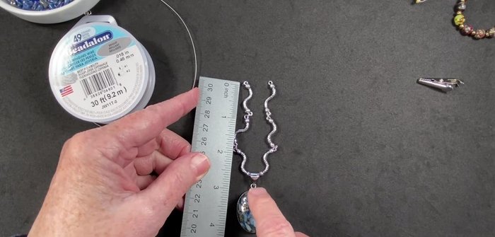 Attach one end of each wire to a clamshell bead tip using crimp beads. Secure the crimp bead by crimping it with pliers.