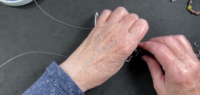 String beads onto the wire: silver beads, sodalite beads, pearls, and oval beads. The video demonstrates a specific pattern, but you can adjust to your preference.