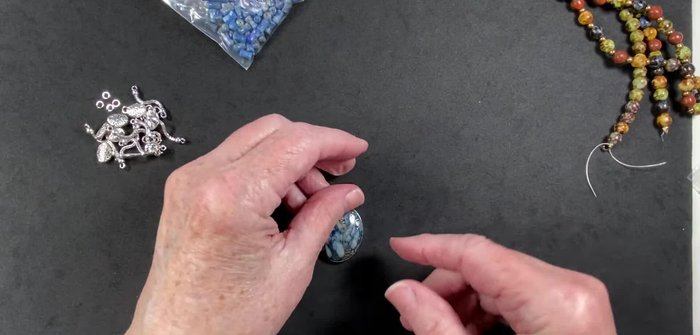 Gather materials: silver beads, necklace with blue beads, gray iridescent pearls, blue sodalite bone-shaped beads, oval metal beads, unusual connectors, jump rings.