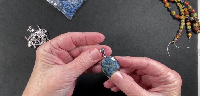 Attach the pendant focal point to the existing pendant bale using jump rings.