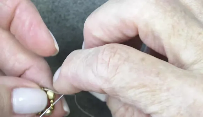 Add another round of beads: 11/0, Delica, 11/0 around each fire polish bead, pushing them in front of the fire polish beads.