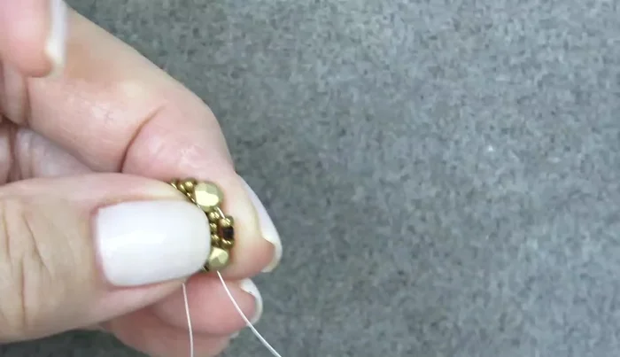 Add another round of beads: 11/0, Delica, 11/0 around each fire polish bead, pushing them in front of the fire polish beads.