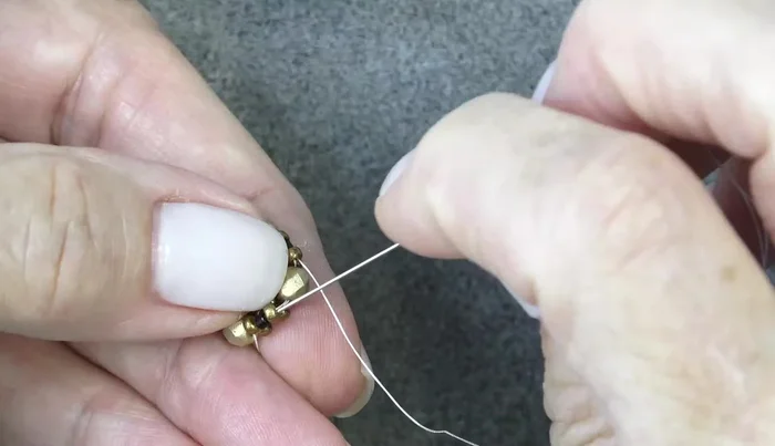 Add bugle beads, exiting one group of 11/0, Delica, 11/0 and sewing through the next. Repeat three more times.