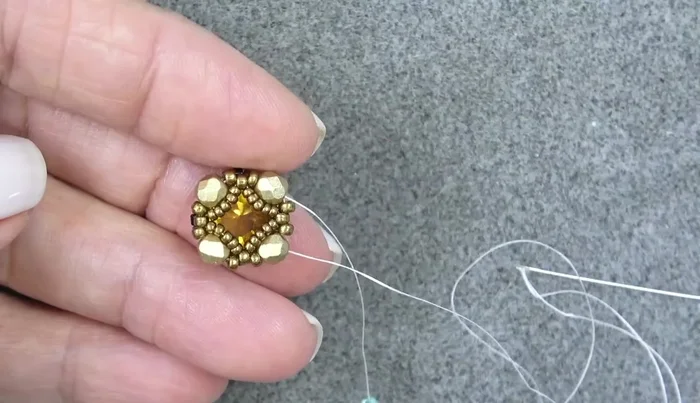 Add two 15/0 seed beads, exiting three 15/0s and sewing through the next three. Repeat two more times.