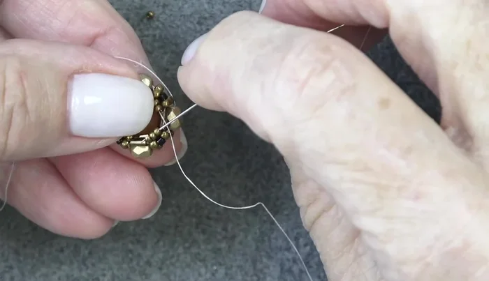 Add two 15/0 seed beads, exiting three 15/0s and sewing through the next three. Repeat two more times.