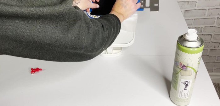 Spray adhesive on the back of one black felt piece and adhere it to the stabilizer.