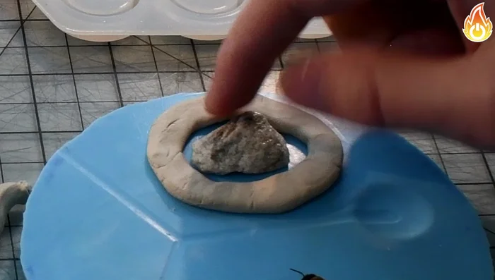 Apply a two-part epoxy resin to the rock, using a heat gun to remove any trapped bubbles.