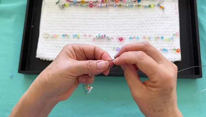 Add the crystal: Thread on a crystal bead, tie an overhand knot, and continue stringing beads until finished.