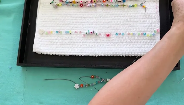 Create the loop: Use a straw to create a barrel knot at the end of the bracelet for easy closure.