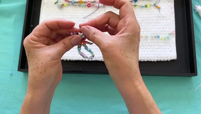 Finish and wear: Tie off the ends, trim the excess cord, and loop the bracelet around your ankle.