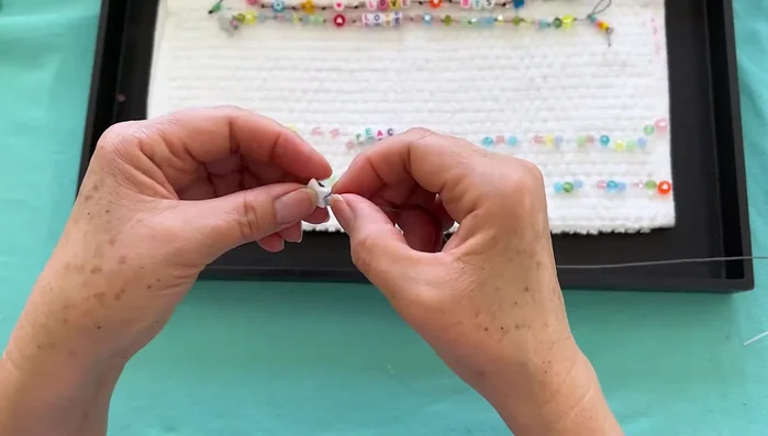 String the beads: Create sets of three beads and tie a knot after each set. Remember to flip the 'HOPE' beads upside down before stringing to ensure correct orientation on the ankle.