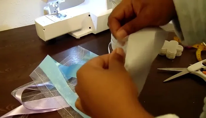 Gather and tie elastic: Pull both ends of the elastic until the ruffles form. Tie the elastic ends tightly in a knot and melt the ends with a lighter to secure.