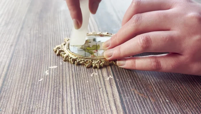 Apply the transfer to the brooch using an applicator tool, ensuring proper alignment. Seal with a water-based sealer, avoiding the gold paint.