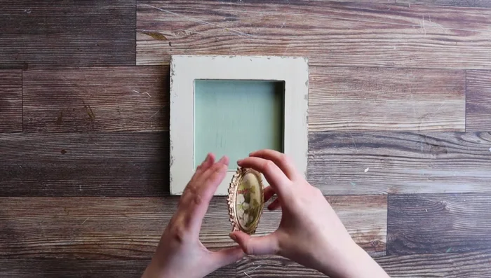 Apply quick-drying glue generously to the back of the brooch and attach it to the shadow box.