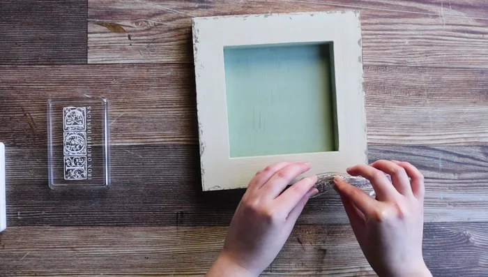 Add aging effects by using custom-mixed IOD inks and applying the Vintage Texture stamp to the shadow box edges.